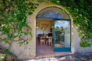 een gewelfde deur naar een patio met een tafel en stoelen bij Tenuta Sant'Andrea in Muro Leccese