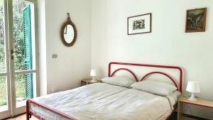 Un dormitorio con una cama y un espejo y una ventana. en N107 - Numana, villetta con giardino, en Numana