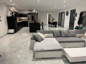 a living room with a couch and a kitchen at Magnifique villa proche ruoms vallon pont darc in Grospierres