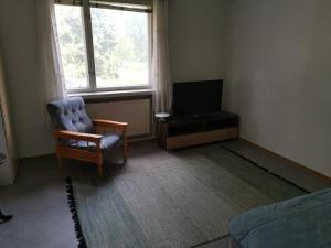 a living room with a chair and a television at Linnantie 2 in Mikkeli