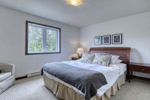 een slaapkamer met een groot bed en een raam bij 146 Borealis - Close to the Mountains in Mont-Tremblant in Mont-Tremblant +27 foto's