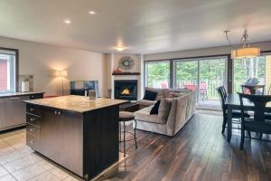 een keuken en een woonkamer met een bank en een open haard bij 146 Borealis - Close to the Mountains in Mont-Tremblant in Mont-Tremblant