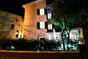 a building with a tree in front of it at night at Romantico B&B in Serra SantʼAbbondio