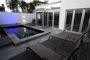 a patio with a pool and two chairs and a table at Boutique Home, The Peak of Luxury in Cape Town