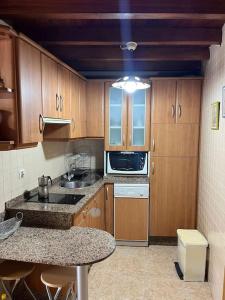 a kitchen with wooden cabinets and a counter top at La casa del valle in Viveiro +8 photos