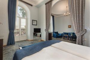 a bedroom with a bed and a living room at Hotel Bella Casa in Tbilisi City