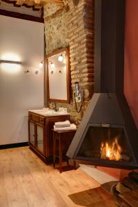 y baño con chimenea, lavabo y espejo. en Hotel La Freixera, en Solsona