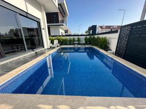 a swimming pool on the side of a house at Belek Tatil Villa in Belek