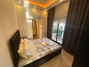 a bedroom with a bed with a large window at Belek Tatil Villa in Belek