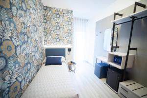 a bedroom with a bed and a wall with a mural at Hotel All'Orologio 3 Stelle Superior in Caorle