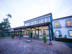 a large blue building with potted plants in front of it at Hotel Escola Bela Vista in Volta Redonda