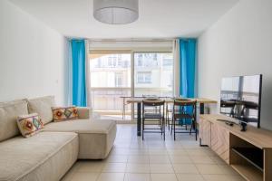 a living room with a couch and a table at Spacieux 3 pièces à 200m des plages in Antibes