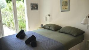 a bedroom with a bed with black pillows and a window at Chez Jaggy in Carqueiranne