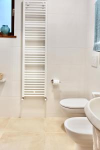 a white bathroom with a toilet and a sink at Casa Azalea in Luino