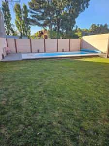 a swimming pool in a yard next to a fence at Refugio El Condor in Balneario El Condor