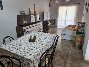 a room with a table with chairs and a kitchen at Refugio El Condor in Balneario El Condor