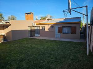 a house with a grass yard in front of it at Refugio El Condor in Balneario El Condor