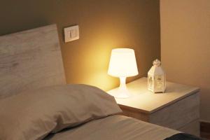 a lamp on a night stand next to a bed at LadimoradiLu' in Fisciano
