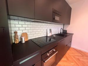 a kitchen with a black counter top and a sink at Chez Jaggy in Carqueiranne