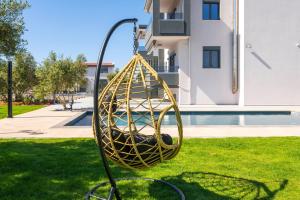 a yellow swing in a yard next to a building at Luxury Oasis in Chania - Private Pool, BBQ & Garden by WeHome in Chania Town
