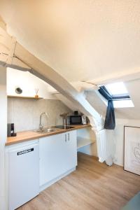 Una cocina con fregadero y un techo con ventana. en Le Cocon : studio en Hypercentre Cathédrale, en Amiens 2 fotos más