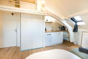 sala de estar con armarios blancos y cocina en Le Cocon : studio en Hypercentre Cathédrale, en Amiens