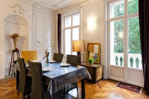 a dining room with a table and chairs and a window at La Suite Joli Coeur - Appt type Ecole de Nancy in Nancy +6 photos