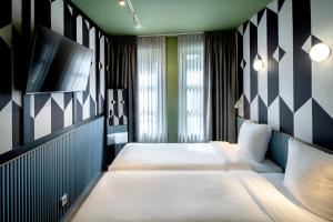 a bedroom with two beds and a flat screen tv at Budget Hotel Tourist Inn in Amsterdam