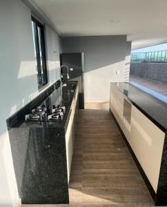 eine Küche mit einer schwarzen Arbeitsplatte und einem Herd in der Unterkunft Flat 304 Porto Prime com Rooftop e Piscina in Porto De Galinhas