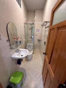 un bagno con lavandino, water e specchio di Gia Hạ House View Đồi Thông-Pine hill-R21 a Da Lat