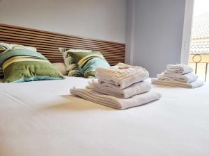 a pile of towels sitting on top of a bed at EL RINCÓN DE SAN NICOLÁS in Soria