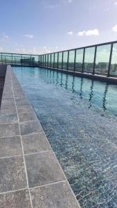 una gran piscina de agua con una pasarela en Flat 305 Porto Prime com Rooftop e Piscina, en Porto de Galinhas