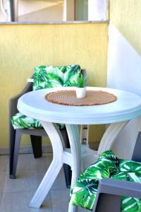 a white table with a plant on it next to a chair at Aqua Studio - Sveti Vlas in Sveti Vlas