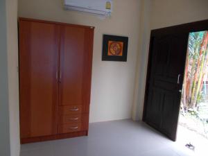 a bedroom with a wooden cabinet and a door at Absolute calm for long sleepers and others in Kamala Beach