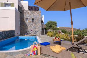 PosidhoníaにあるStelios-Korina Villa with Pool and Stunning View in Syros Posidoniaの家の隣にある傘付きのスイミングプール