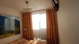 a bedroom with a window and a bed with avertisement at Prezident in Dilove