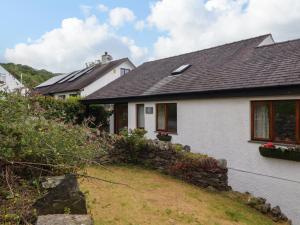 una casa blanca con un muro de piedra en Becks Fold, en Coniston
