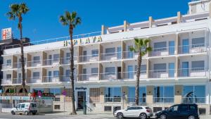 a hotel with palm trees in front of it at Hotel Playa in Peñíscola