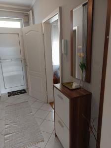 a room with a refrigerator and a counter with a mirror at Lia Apartman in Nyíregyháza