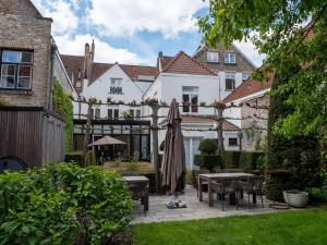 a patio with tables and umbrellas in a yard at B&B Anna9 in Bruges