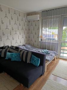 a living room with a couch and a bed at Lia Apartman in Nyíregyháza