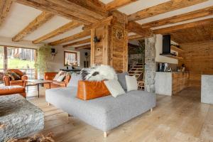 a living room with a couch and a fireplace at Chalet Dolomites Luxe con Spa, Piscine, Jacuzzi e Cinema Privato in Livinallongo del Col di Lana