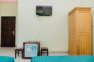 a room with a tv and a table and chairs at Hotel Thuý Lan in Long Hai