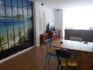 sala de estar con mesa, sillas y una pintura en OLIVA WIFI HOME, en Oliva