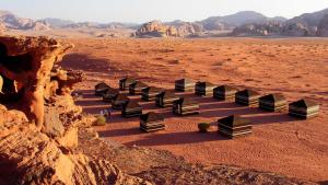 a row of black benches in the desert at Salem Camp in Wadi Rum