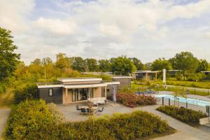 a small house with a patio and a pool at Panorama wellnesslodges x Vakantiepark Hölte in Rijssen