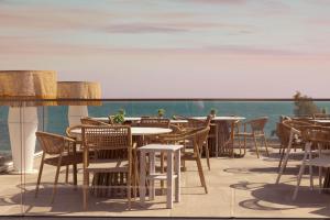 a restaurant with tables and chairs on a balcony at Acron Suites in Limenaria