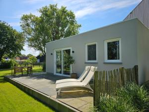 een witte stoel op een patio voor een huis bij Vakantiewoning Studio 51 OK49 in Oostkapelle