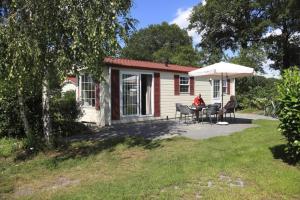 a woman sitting at a table in front of a house at Camping Heino in Heino