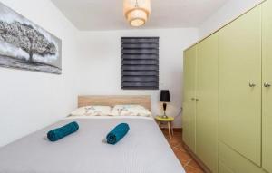 a bedroom with a bed with two blue pillows on it at Apartments Casa al Vento in Donja Klada